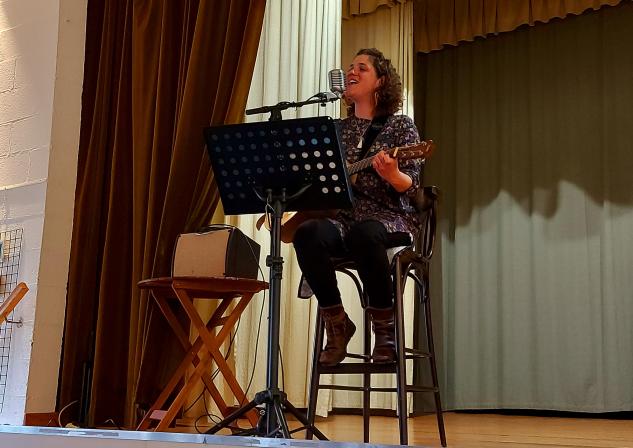 Charlotte Renwa qui chante et joue de la guitare sur la scène