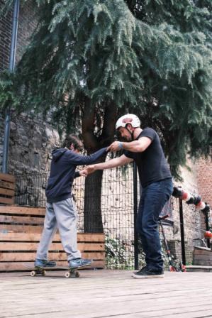 Squatteur aidant un.e enfant sur une planche de squat.