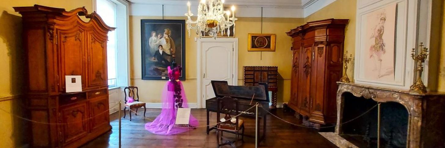 Exposition Les Bateliers, pièce de vie avec robe et piano